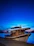 Elegant floating luxury boat docked at sunset with warm wooden textures and nautical blue tones.