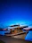 Elegant floating luxury boat docked at sunset with warm wooden textures and nautical blue tones.