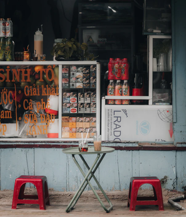 two red stools sitting in front of a store