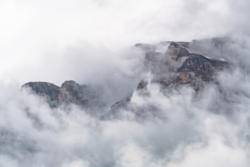 a mountain covered in fog and clouds on a cloudy day