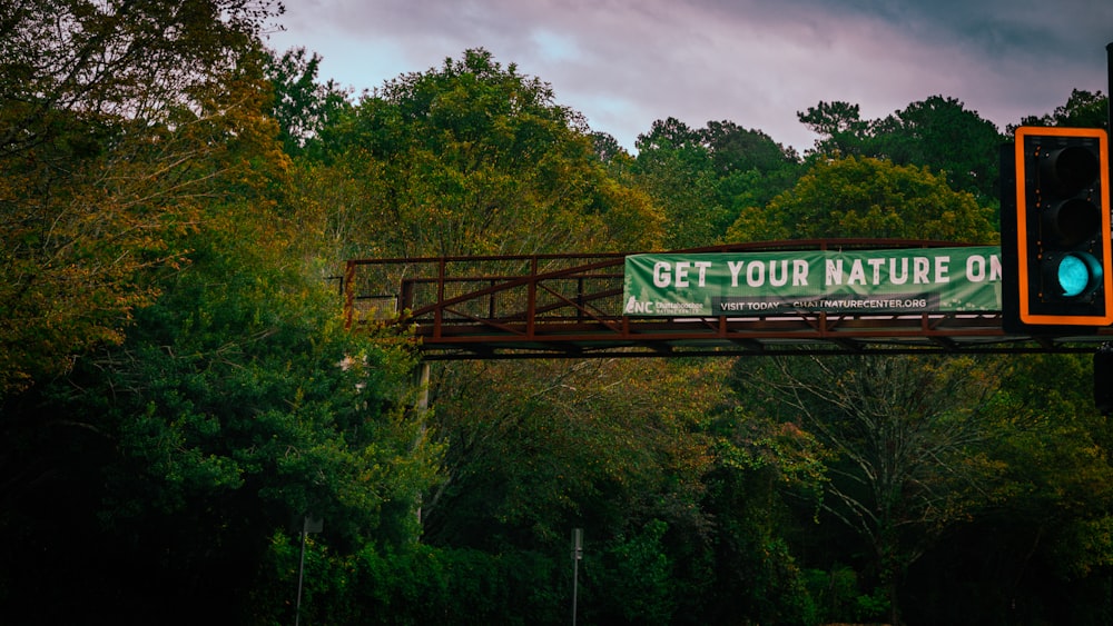 a sign that reads get your nature on a bridge
