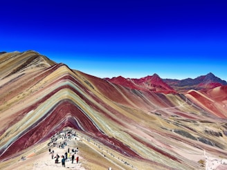 A vibrant Moroccan landscape with hikers exploring a scenic mountain trail.