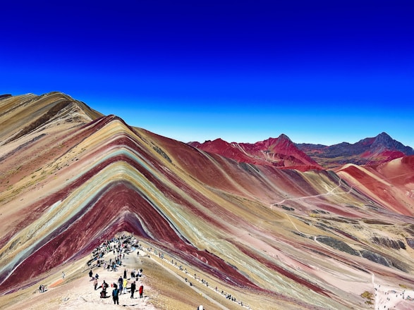 A vibrant Moroccan landscape with hikers exploring a scenic mountain trail.