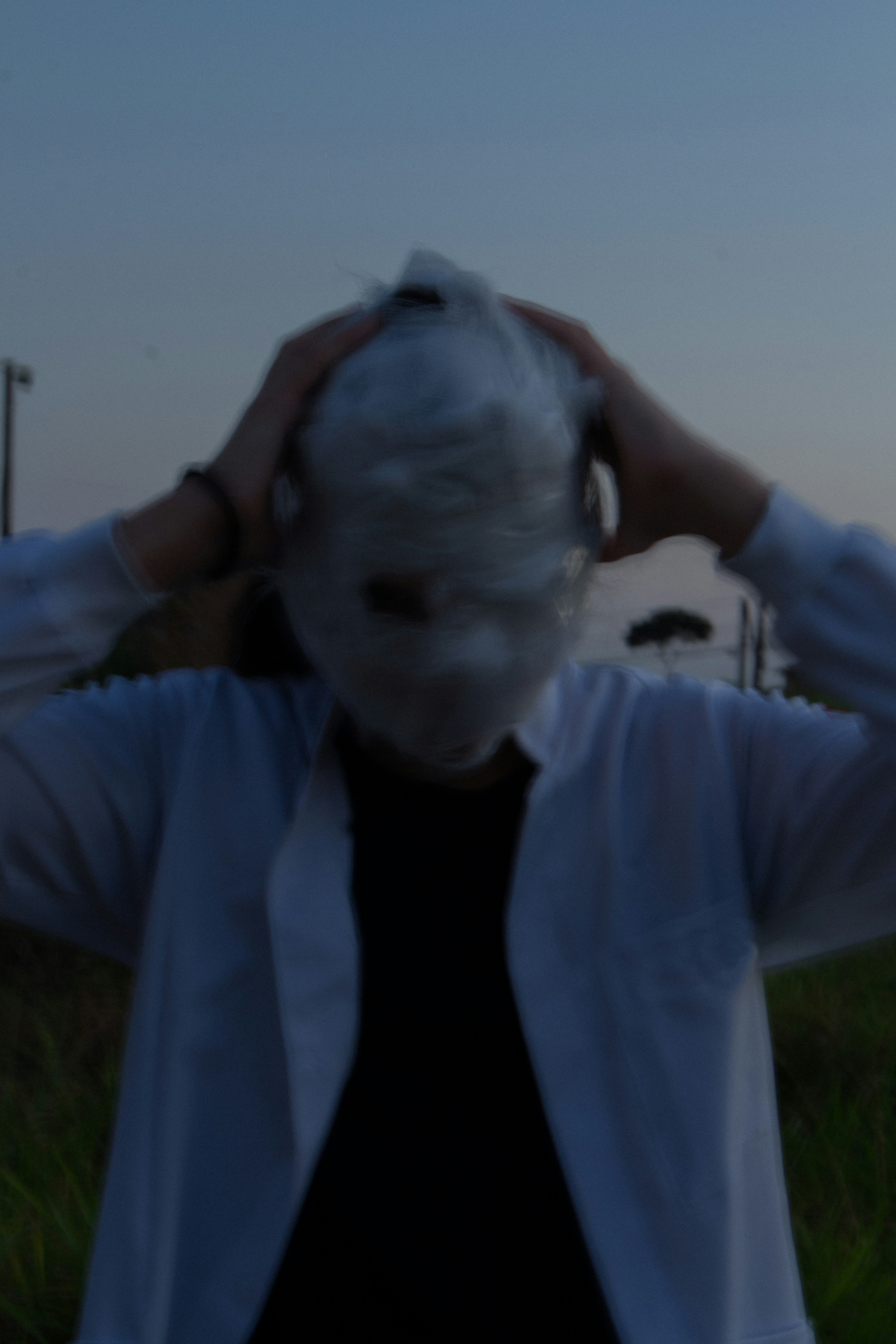 a woman with white hair and a white mask covering her face