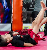 Children practicing karate moves enthusiastically during an online class.