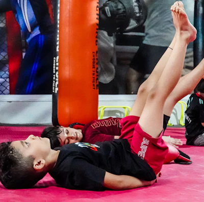 Children practicing karate moves enthusiastically during an online class.