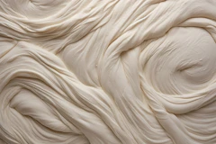 Close-up of thick, cream-coloured paste swirled into soft folds with gentle shadows (stand-in for smooth dermal filler)