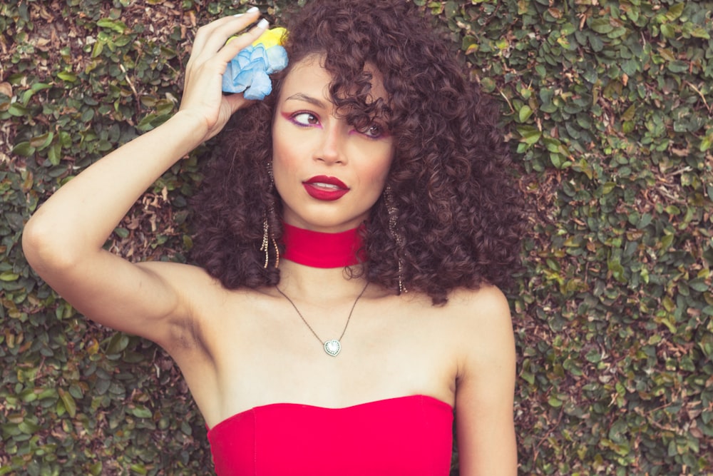 a woman in a red dress holding a blue object