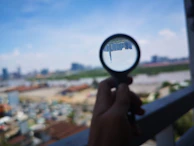 Close-up of hands reviewing blueprints with a city skyline in the background.
