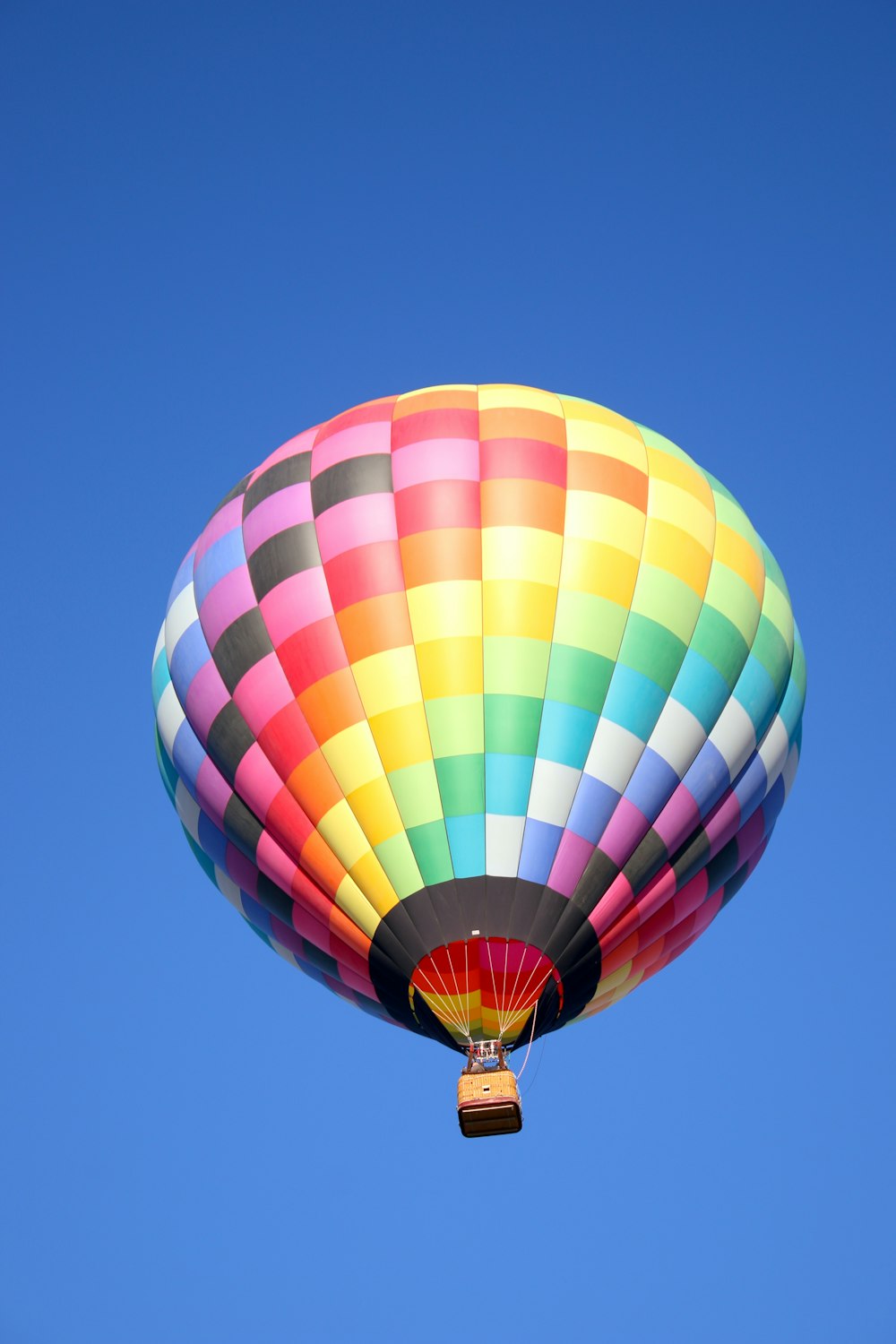 a colorful hot air balloon flying in a blue sky