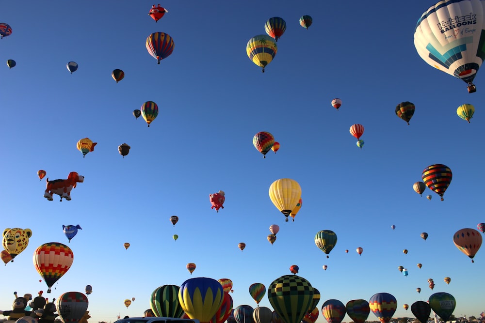 um monte de balões de ar quente voando no céu