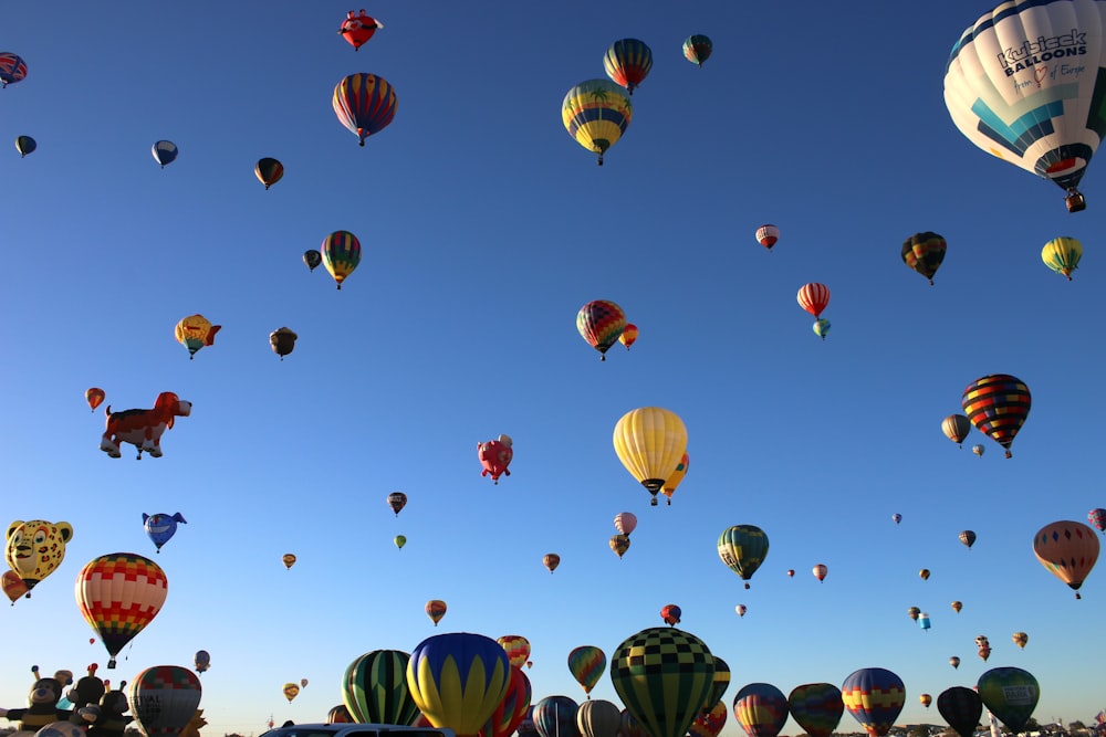 un mucchio di mongolfiere che volano nel cielo