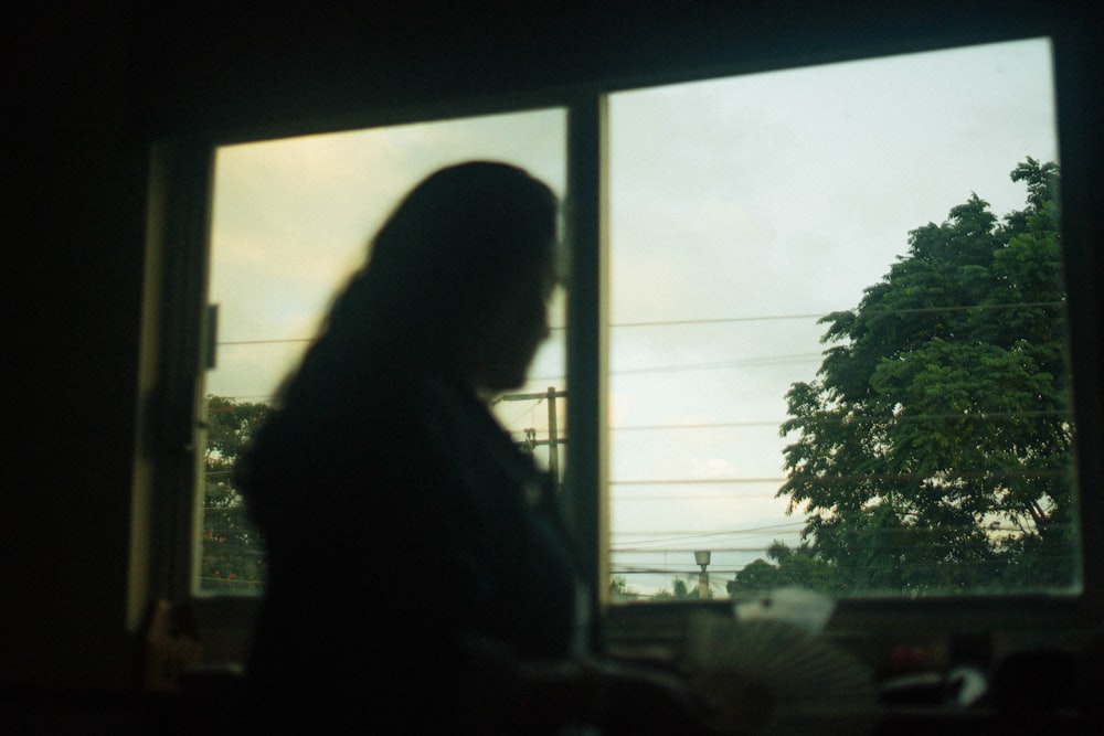 a woman standing in front of a window