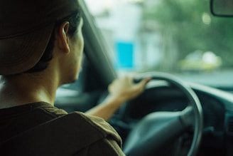 A professional driver in uniform sitting behind the wheel of a vehicle.