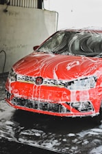 a red car is covered in a lot of snow