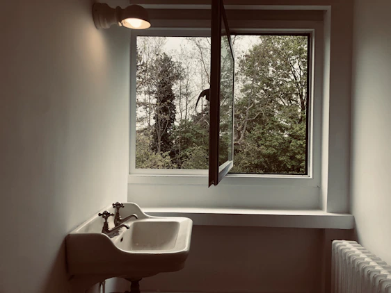 Minimalist interior featuring a custom stone tile sink with soft natural light highlighting textures.