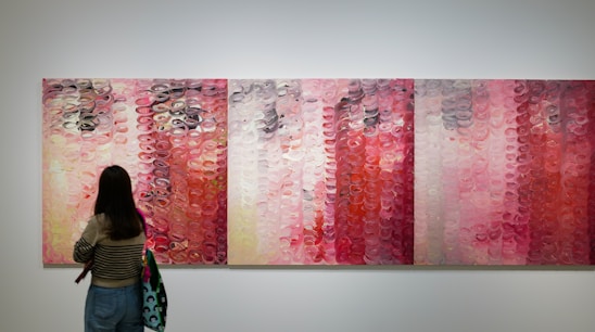 Portrait of Prashalee Gikwad, an abstract artist, standing in front of a large colorful abstract painting.