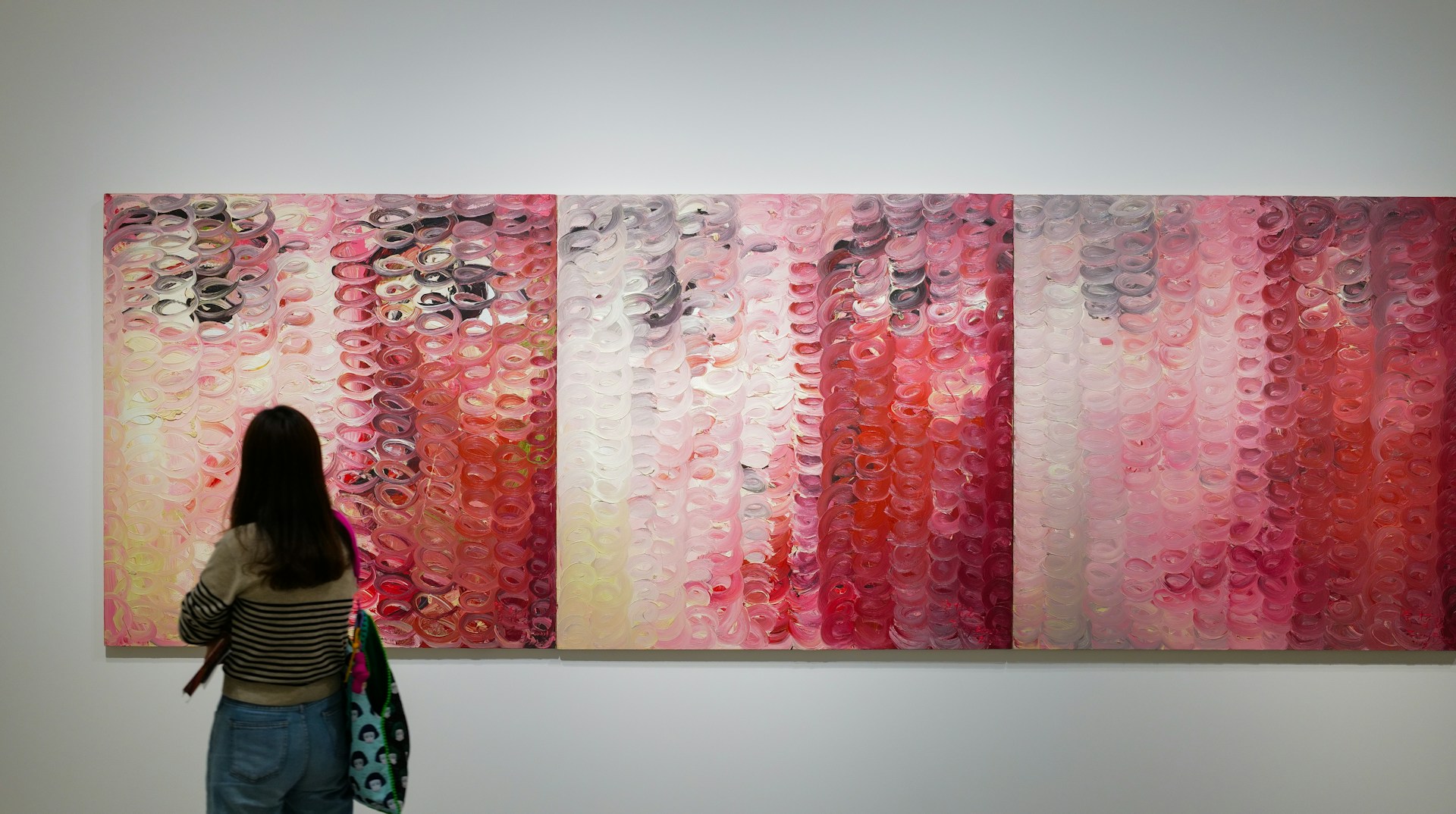 a woman standing in front of a large painting
