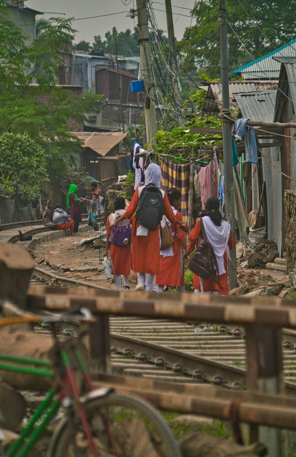 a group of people walking down a train track