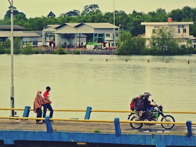 A group of e-bikers riding along a riverside path.