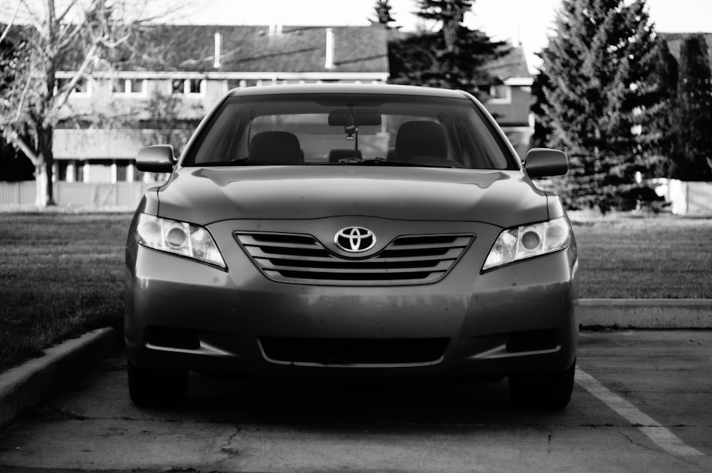 Una foto en blanco y negro de un coche aparcado en un aparcamiento