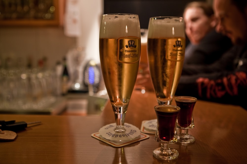 Un par de vasos de cerveza encima de una mesa