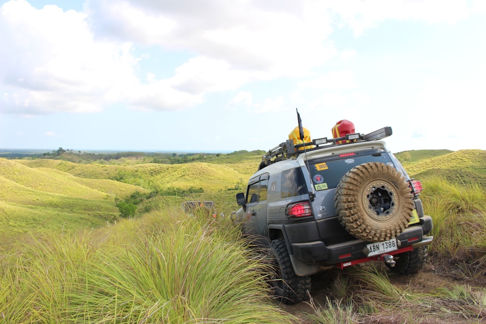 a jeep driving through a lush green field