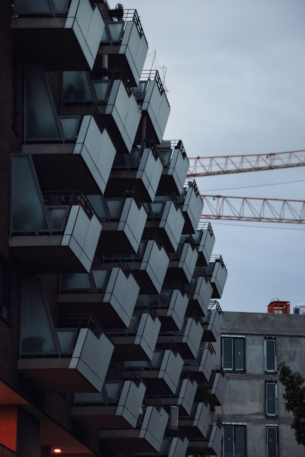 a tall building with a crane in the background