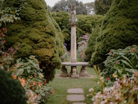 A serene garden design featuring various plants and sculptures.