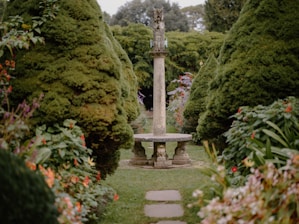 A serene garden design featuring various plants and sculptures.