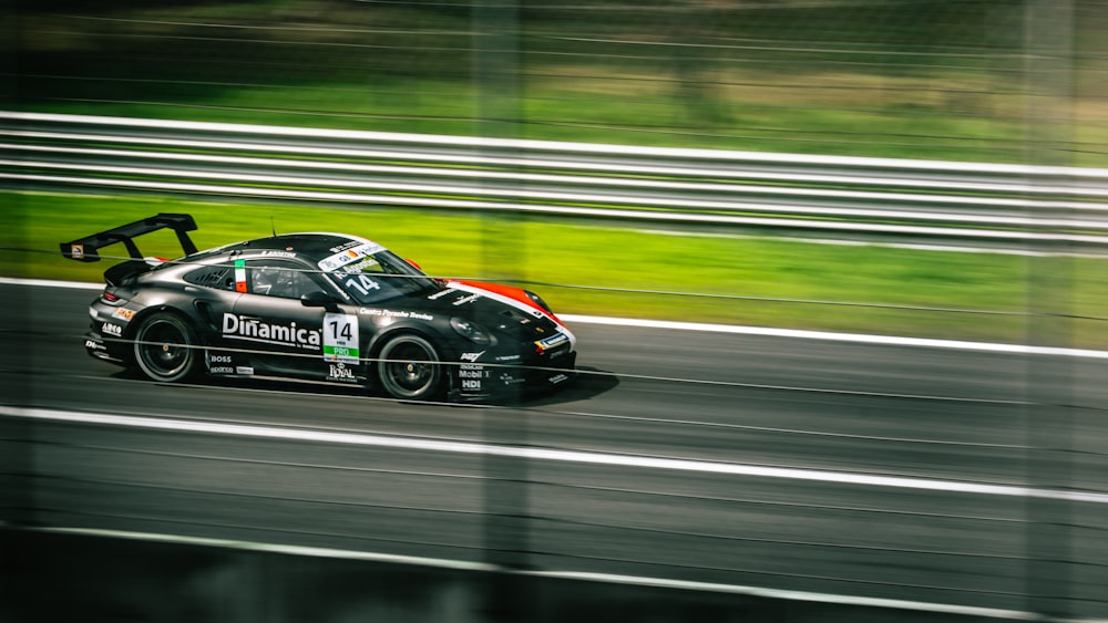 a black car driving down a race track