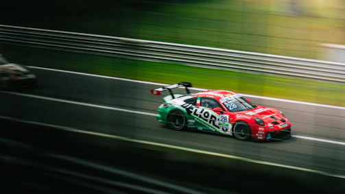 A dynamic shot of a racing car speeding on the track with blurred background.