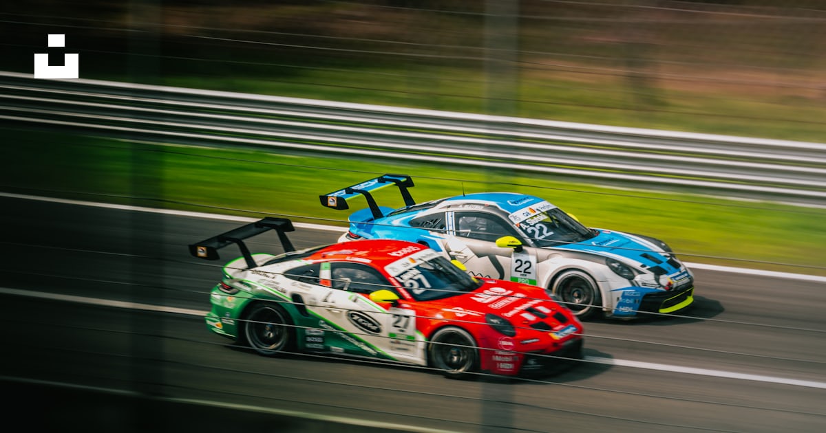 Two race cars racing on a race track photo – Free Car Image on Unsplash