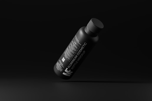 a black bottle with a white cap on a black background