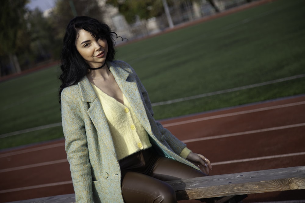 a woman sitting on a bench in front of a track