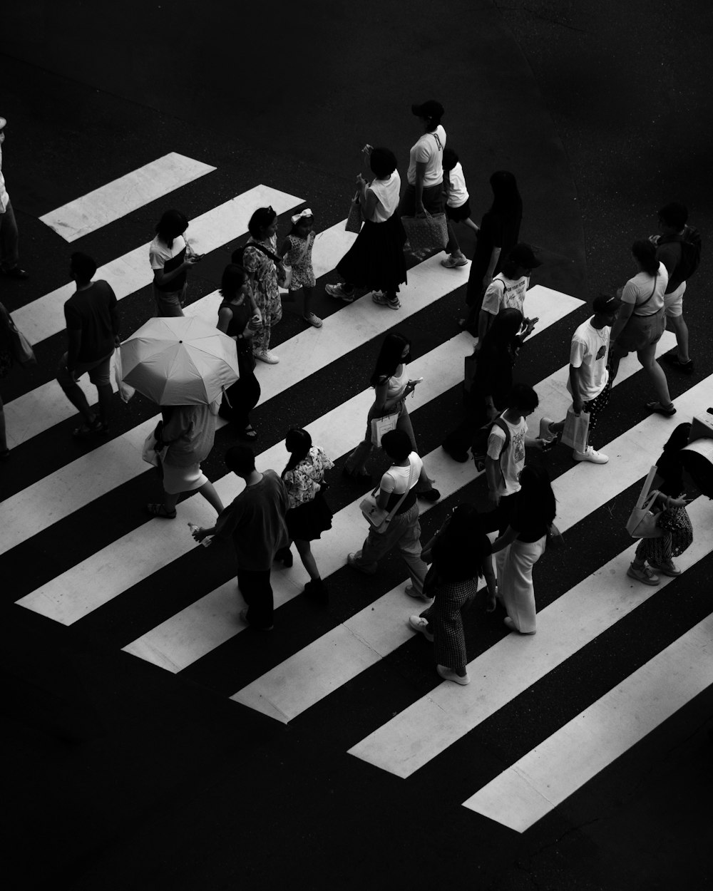 a group of people walking across a cross walk