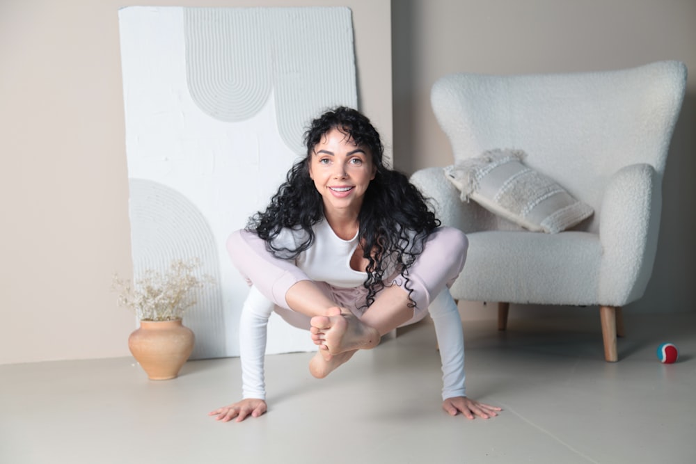 a woman is posing for a picture in front of a chair