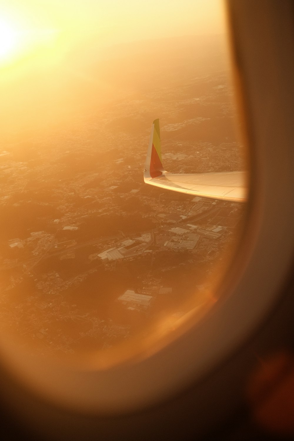 a view of the wing of an airplane as the sun sets