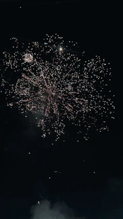 Close-up of colorful smoke and sparkle fireworks lighting up the evening sky at a wedding celebration.