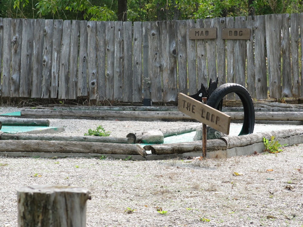 a sign that is in the dirt near a fence