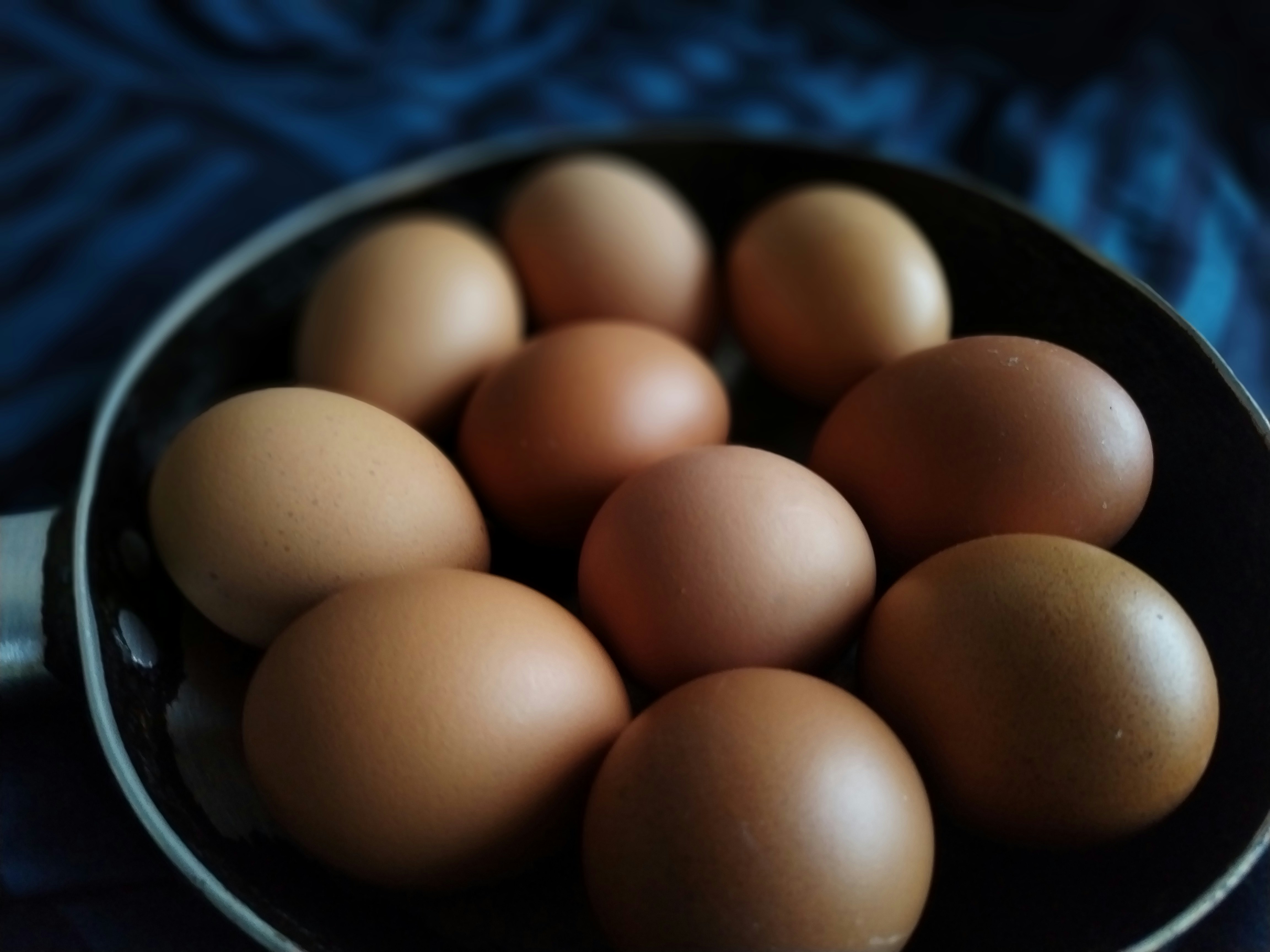 a bunch of brown eggs in a pan