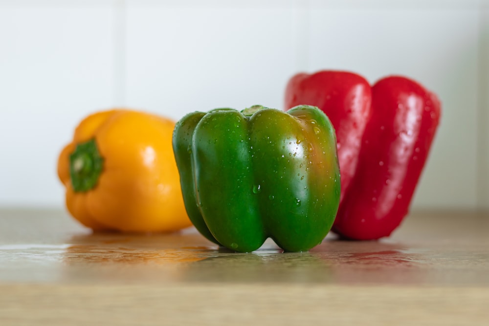 a group of three peppers sitting on top of a counter