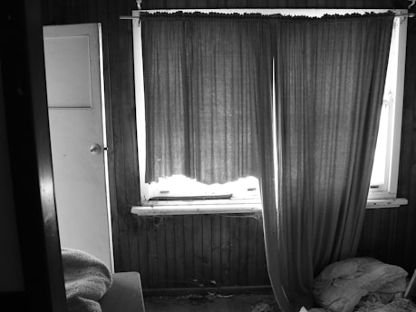 A mysterious, dimly lit room with scattered old letters and a flickering candle casting shadows.