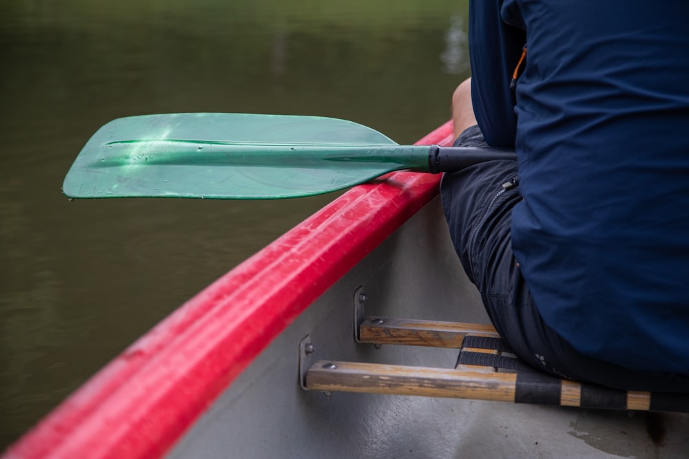 a person sitting in a boat with a paddle