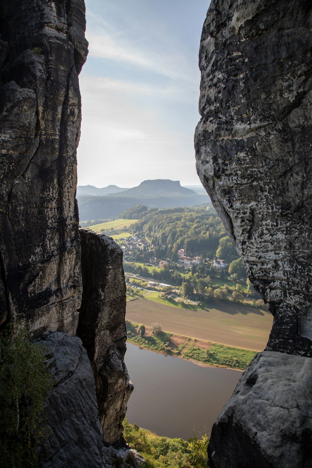 uma vista de um vale através de uma lacuna em uma rocha