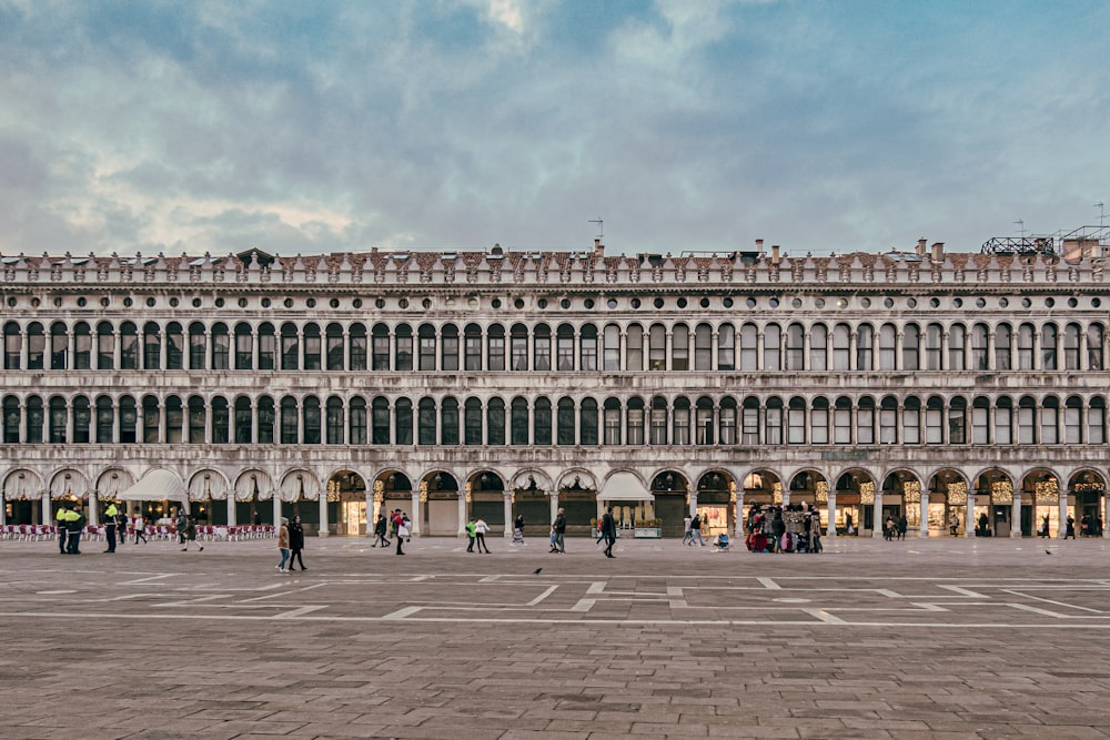 a large building with a lot of windows and people walking around