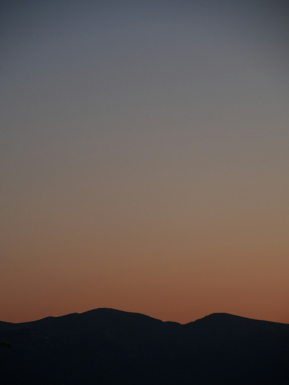 a plane flying in the sky at sunset