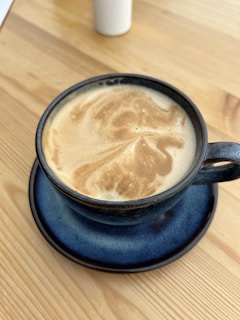 A steaming cup of rich coffee resting on a Chicago Transit Authority work desk, with blueprints and a transit map in the background.