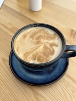 A steaming cup of rich coffee resting on a Chicago Transit Authority work desk, with blueprints and a transit map in the background.