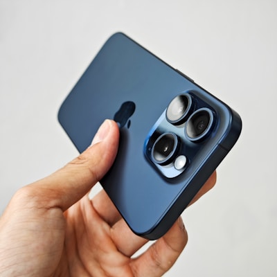 A stylish young person holding a phone with a bold, modern skin design, set against a dark navy background.